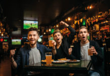 Sports fans in pub drinking beer