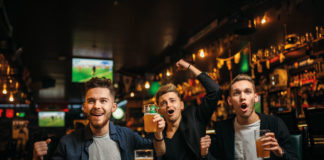 Sports fans in pub drinking beer