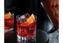 Two cocktails are sitting on a black table