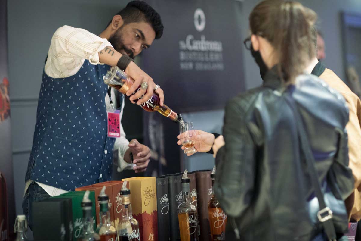 a bartender pours whisky samples