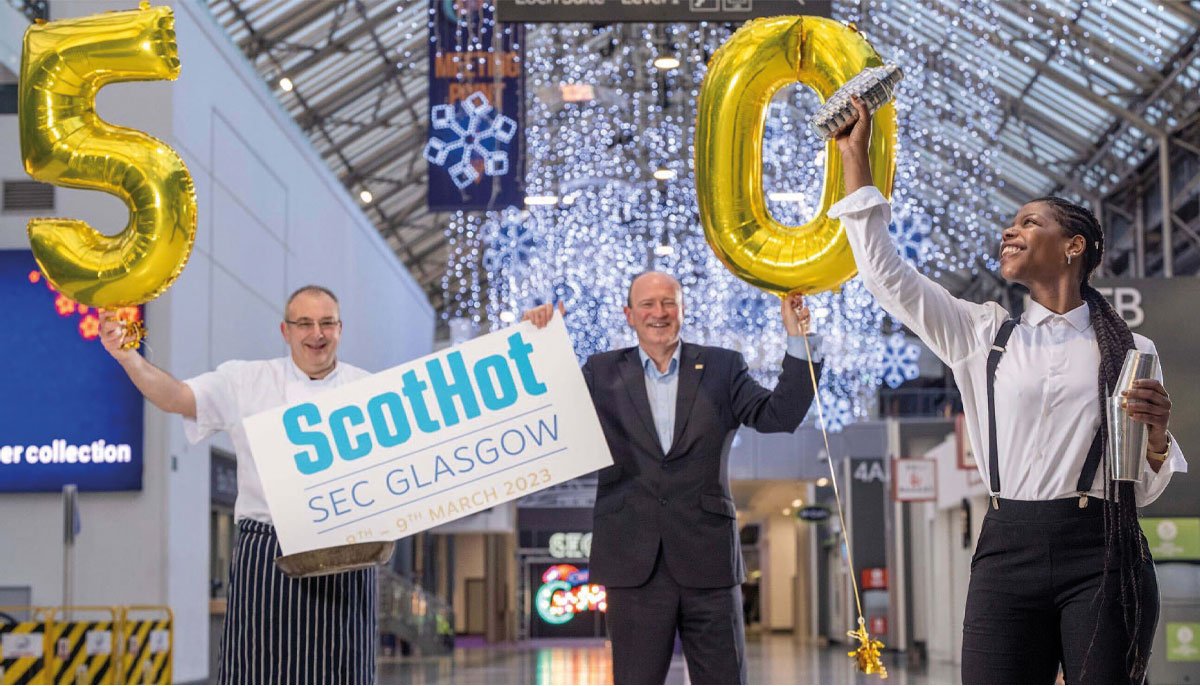 ScotHot staff with sign and '50' balloons