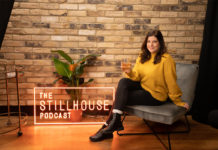 The Stillhouse Podcast sign with woman sitting on chair