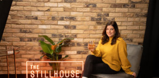 The Stillhouse Podcast sign with woman sitting on chair