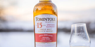A bottle of whisky and a dram embedded in snow