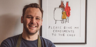 A young chef stands in front of a kitchen related pun