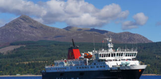 a caledonian macbrayne ferry leaves arran with forest and mountains in the background