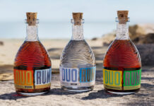 three bottles of duo rum on a beach