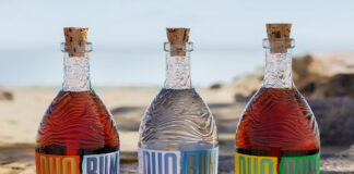 three bottles of duo rum on a beach