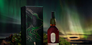 lagavulin whisky carton and bottle on mossy terrain with a green sky in the background