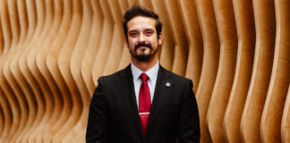 Veteran bartender and mixologist Brad Price in a formal suit against a carved wood background