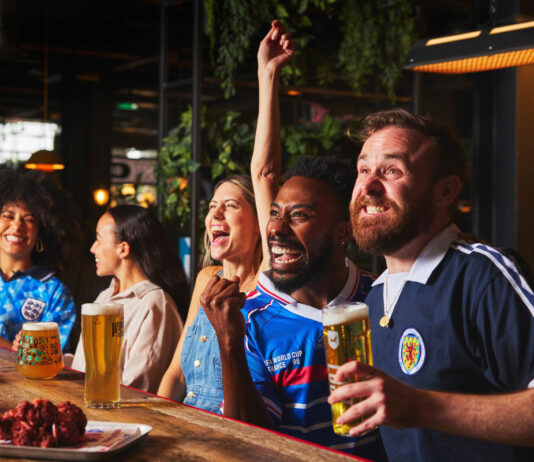 Football fans watch a game in a pub