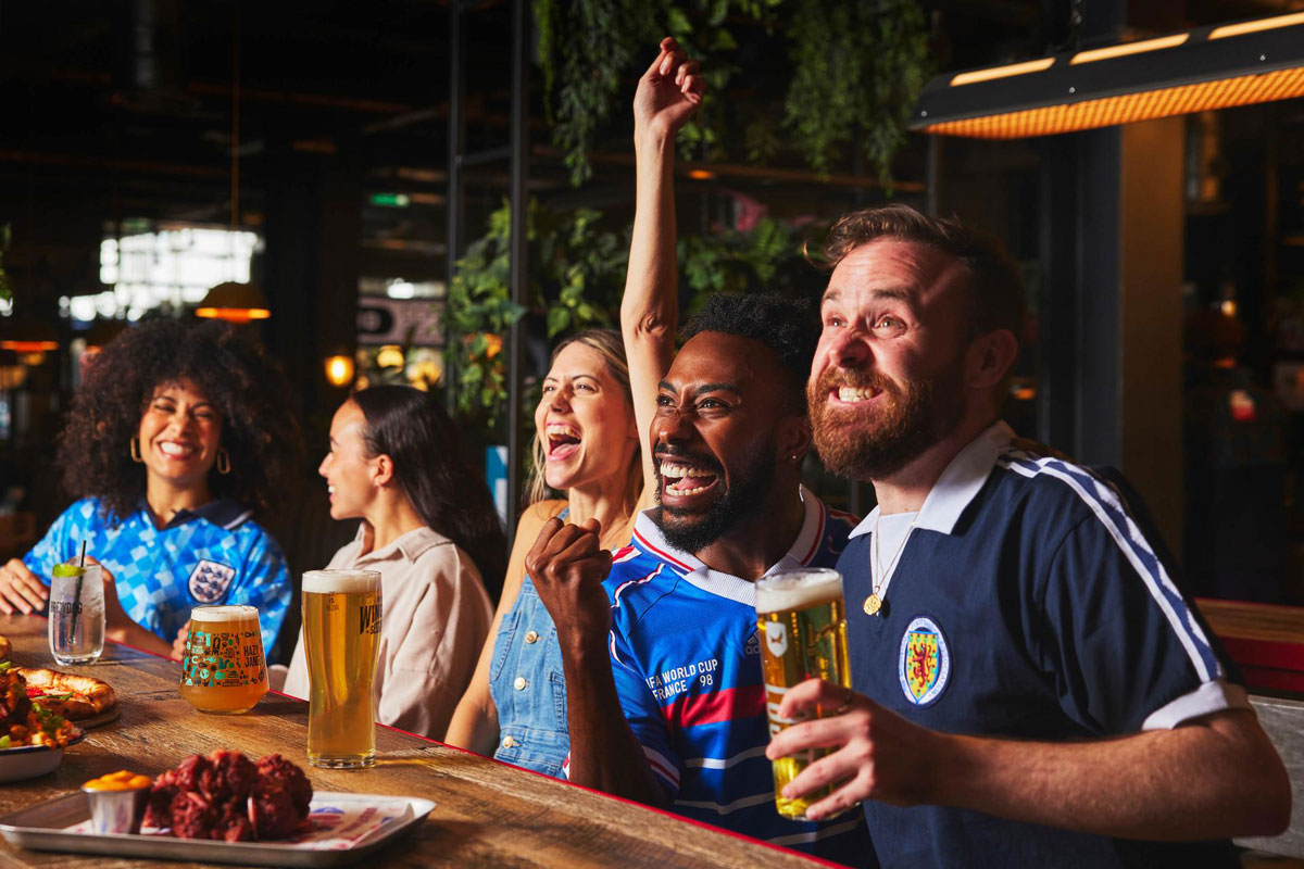 Football fans watch a game in a pub