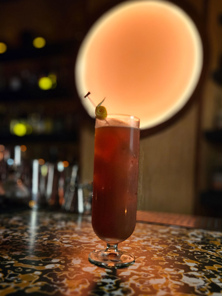 A dark cocktail in a tall glass