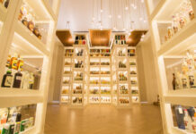 A brightly lit room full of whisky bottles on display