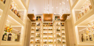 A brightly lit room full of whisky bottles on display