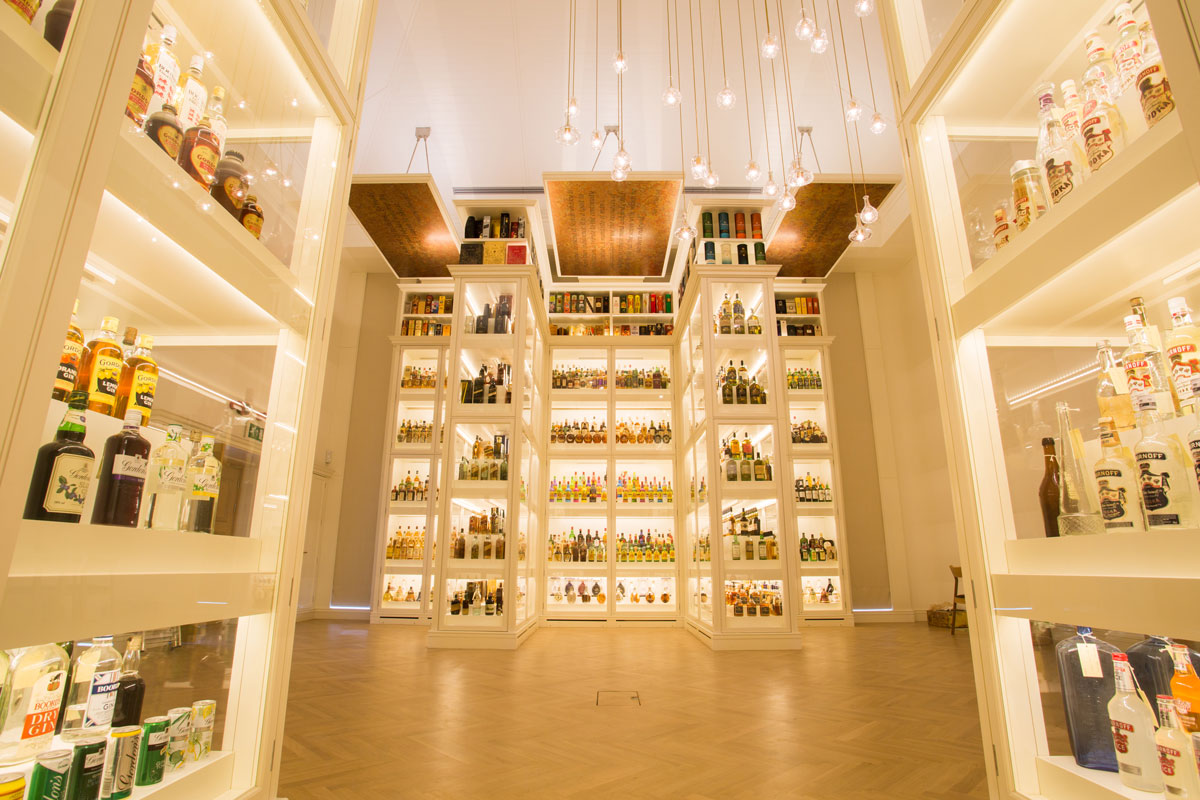 A brightly lit room full of whisky bottles on display