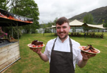 a chef holds two plates of food in a lochside garden at glenfinnan house hotel