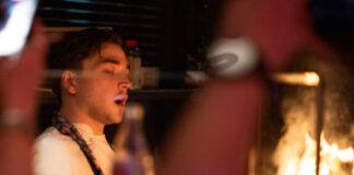 A young chef slaves over flaming grill