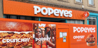 A fast food restaurant under construction, hidden behind colourful screens