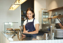 A young asian woman serves in a cafe