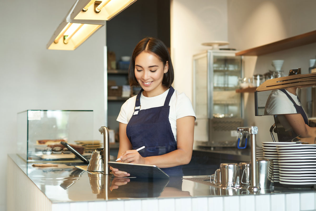 A young asian woman serves in a cafe