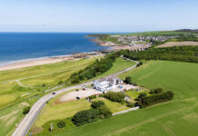 A Scottish seaside hotel, alone amidst green fields