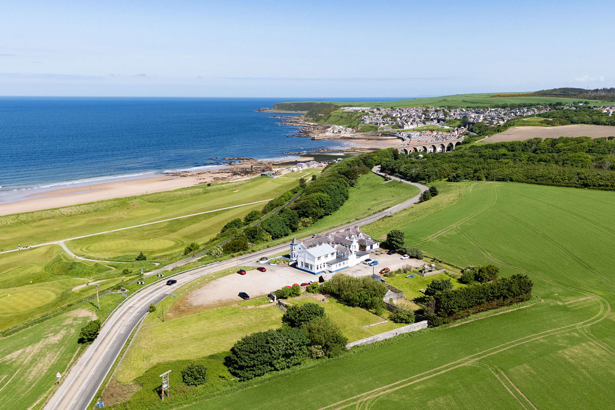 A Scottish seaside hotel, alone amidst green fields