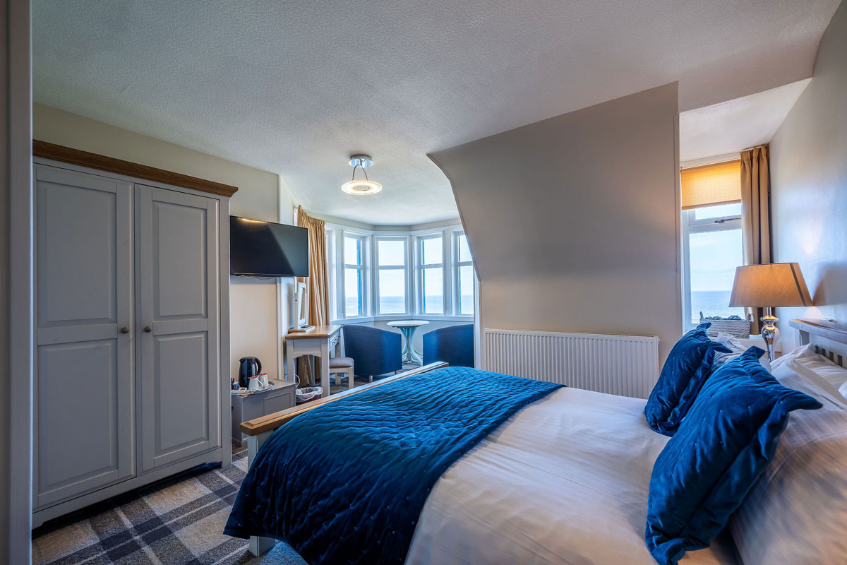 A bright hotel bedroom with sunshine coming in its windows 