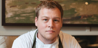 A young chef looks intently at the camera