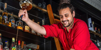 Two bearded bartenders get up to japes with ladders and bottles