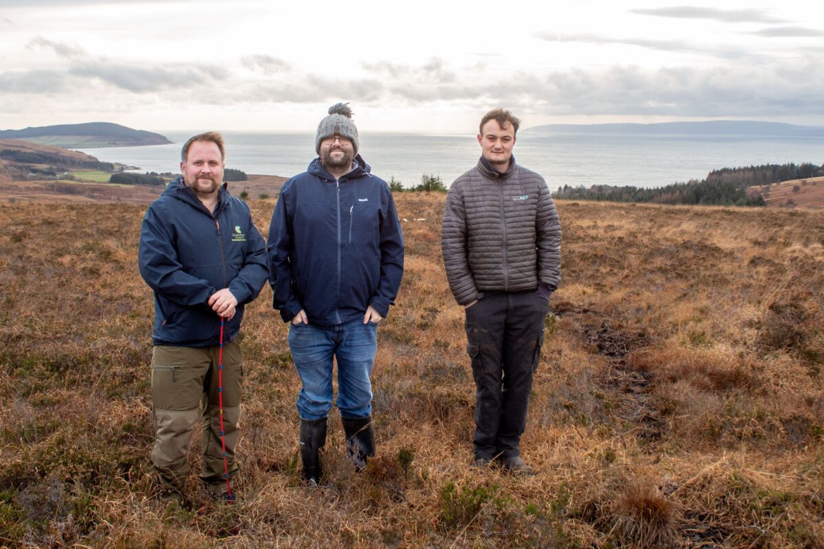Three guys, in warm clothing, out on a Scottish moor
