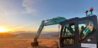 A tracked ground excavator on Scottish moorland in the sunshine.
