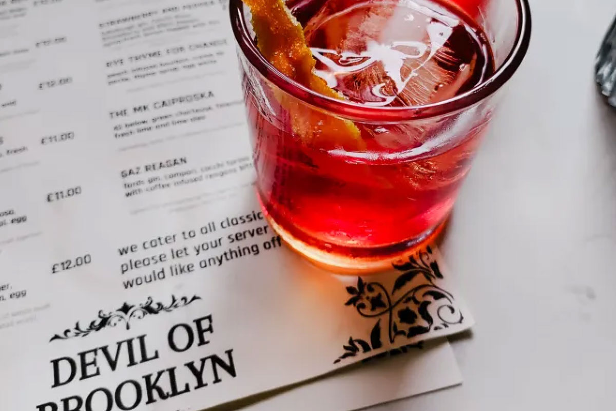 A red drink atop a cocktail menu