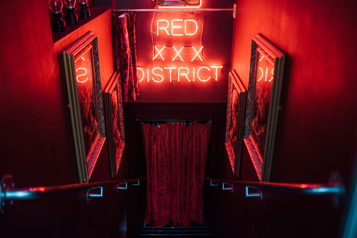 A red neon sign with invitingly seedy sexual connotations