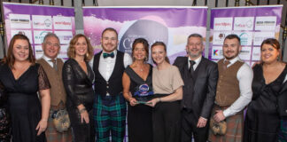 A group of well dressed hoteliers receive an award
