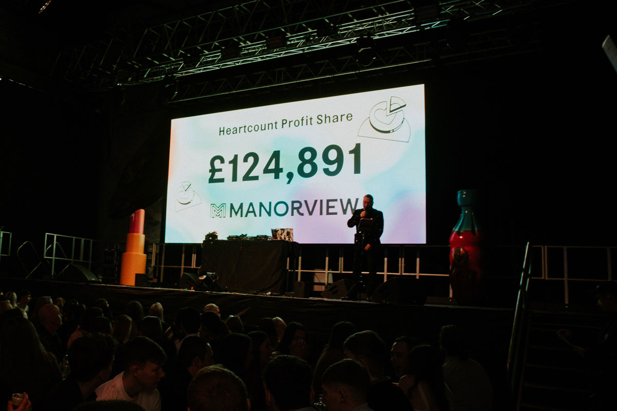 A screen in a darkened room displays the figure £124,891