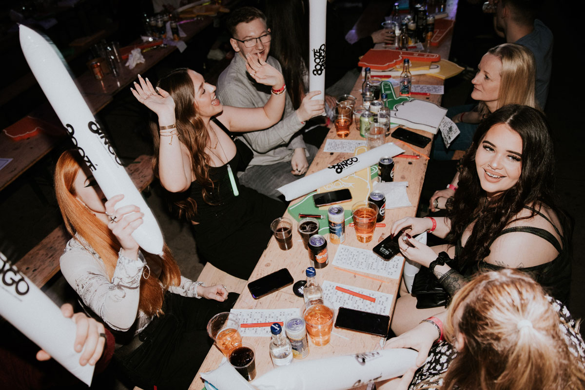 People sat at a trestle table play with inflatable toys