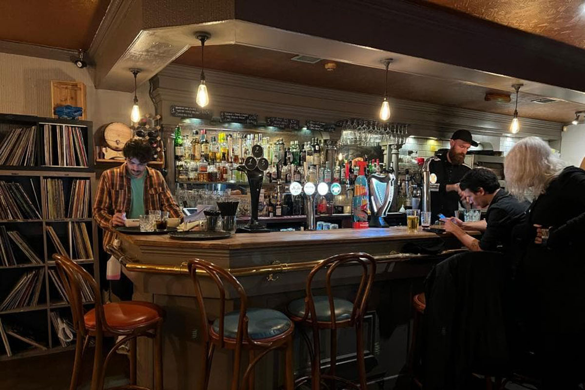 A barman works behind a well-stocked bar