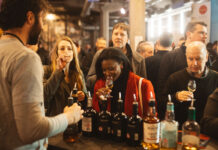 Two ladies sample whisky at a trade stand
