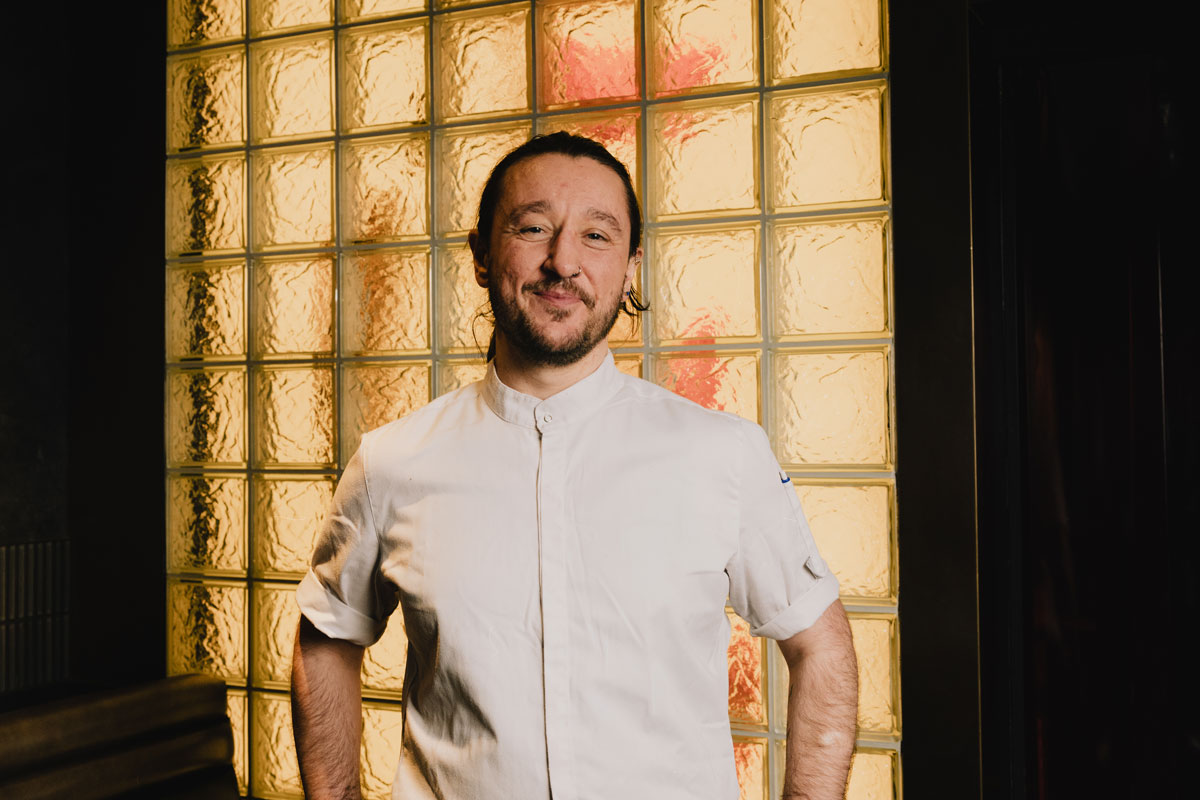 A young bearded man in chef's whites