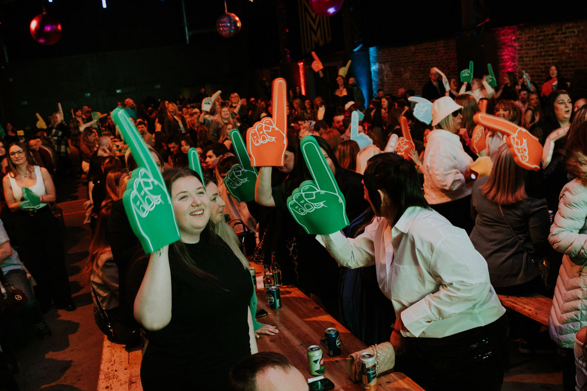A roomful of people wearing 'foam finger' novelty hands