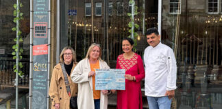 A charity cheque presentation outside a restaurant