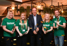 Pub chain raises record £3.9million for Macmillan Cancer Support A man in a suit celebrates with younger people in green charity t-shirts