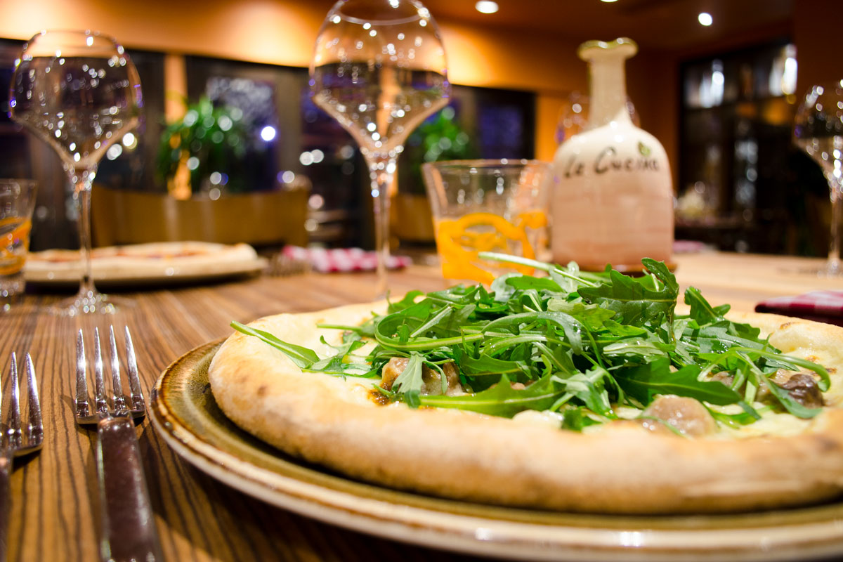 A pizza with fresh leaves on a restaurant table