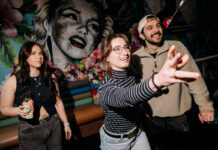 Bath St’s Tiki Bar adds digital darts to Glasgow’s ‘oasis of escapism’ A young woman throws a dart as her friends watch