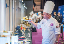 A chef examines a plate of food