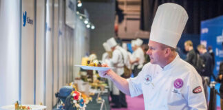 A chef examines a plate of food