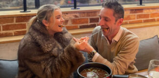 A young couple feed each other meat, and find the experience hilarious