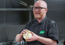 A bearded man demonstrates cookery