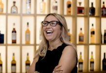 International Women’s Day 2025 – Gillian Dalziel of Diageo A blonde woman laughs in front of shelves full of bottles